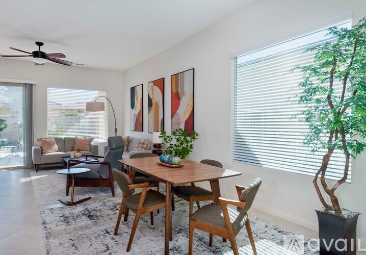 A dining room with a table set for four and a potted plant.