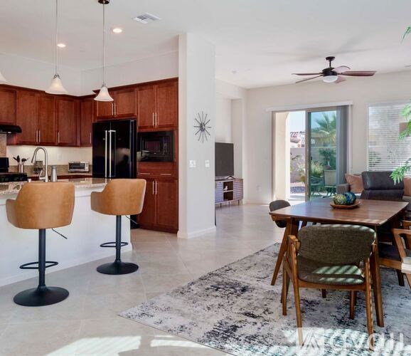 A modern kitchen with wooden cabinets and a black refrigerator.