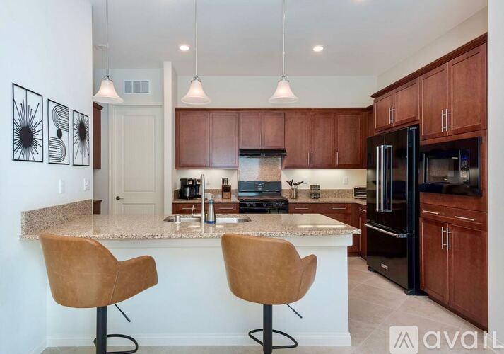 A kitchen with brown cabinets and a marble countertop.