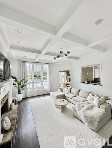 A modern living room with a white sofa and a fireplace.