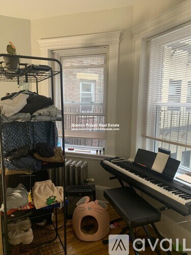 A room with a cluttered bunk bed, a piano, and a cat tree.