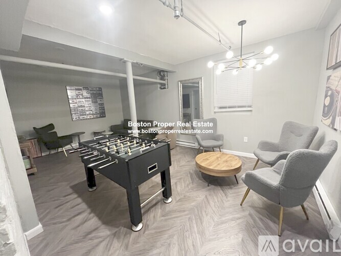 A foosball table is in the middle of a living room with a couch and chair.