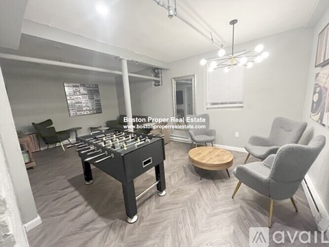 A foosball table is in the middle of a living room with a couch and chair.