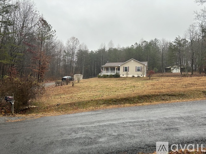 A house is situated in a grassy area with trees in the background.