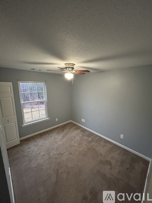 A room with a ceiling fan and a window.
