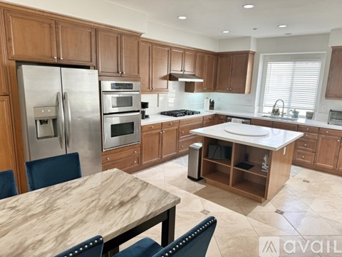A kitchen with wooden cabinets and a marble table.