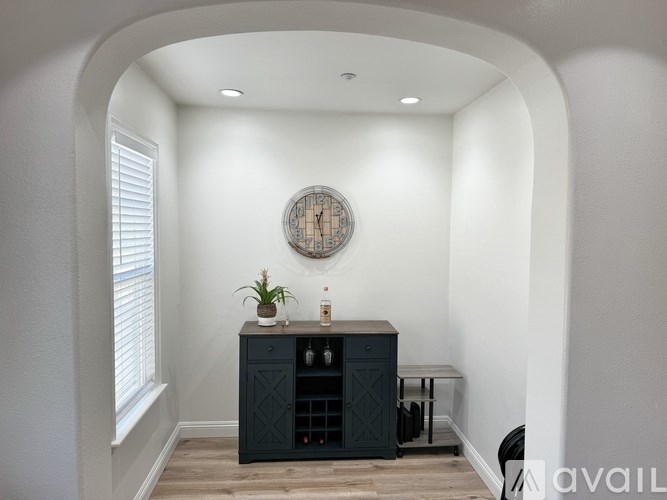 A dark blue cabinet with a clock on the wall above it.
