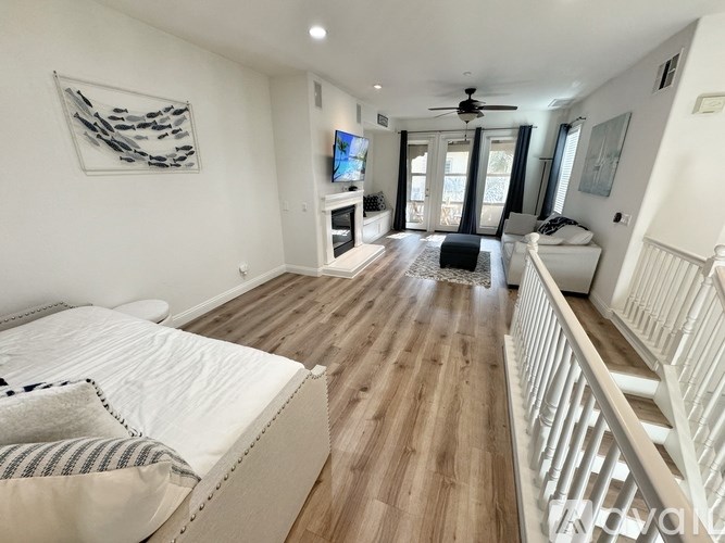 A spacious living room with a white couch and a television.