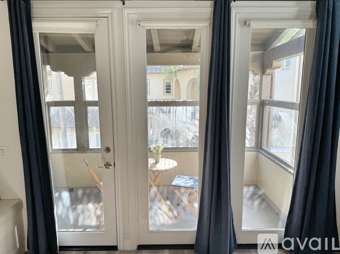 A room with a table and chairs is visible through a glass door.