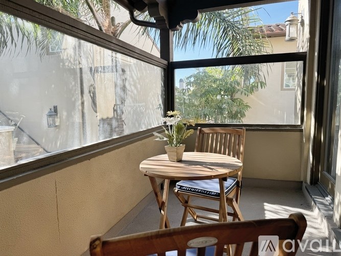 A table with a plant on it sits on a balcony.