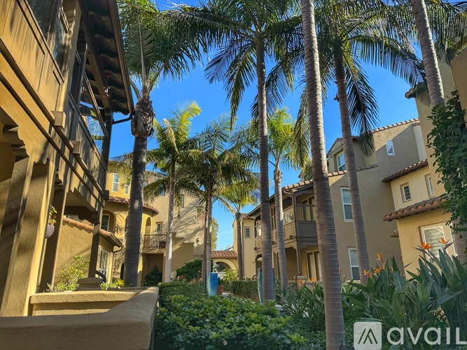A row of houses with palm trees in front.