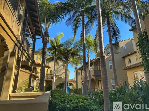 A row of houses with palm trees in front.