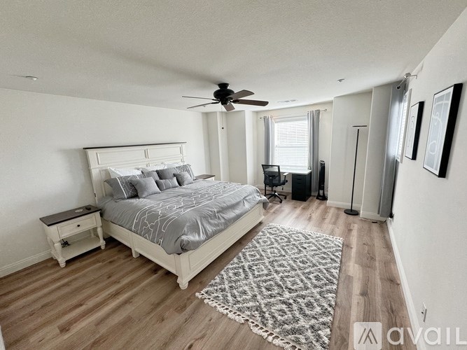 A bedroom with a large bed and a ceiling fan.
