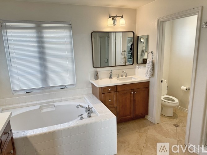 A bathroom with a white tub, sink, and toilet.