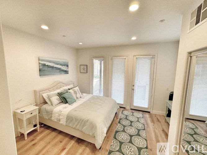 A bedroom with a large bed and a painting on the wall.