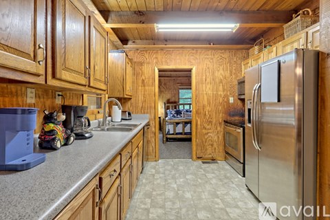 A kitchen with wooden cabinets and a stainless steel refrigerator.