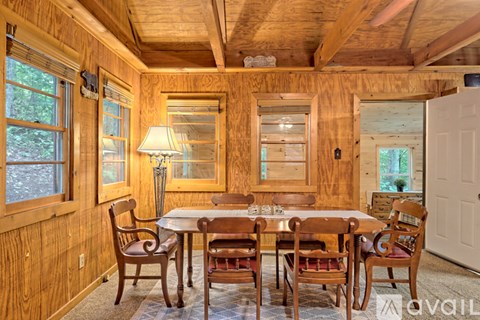 A wooden dining room with a table set for six.