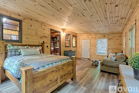 A bedroom with a large bed and wooden furnishings.