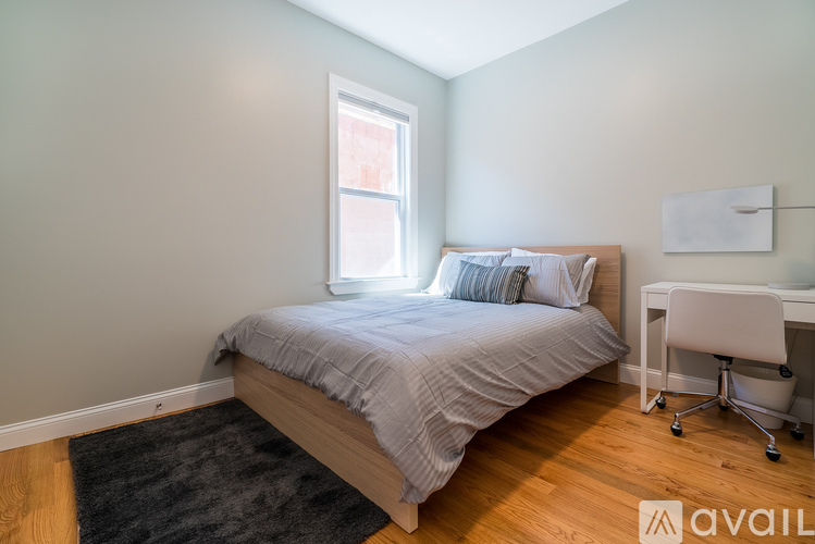A bedroom with a bed, desk, and chair.