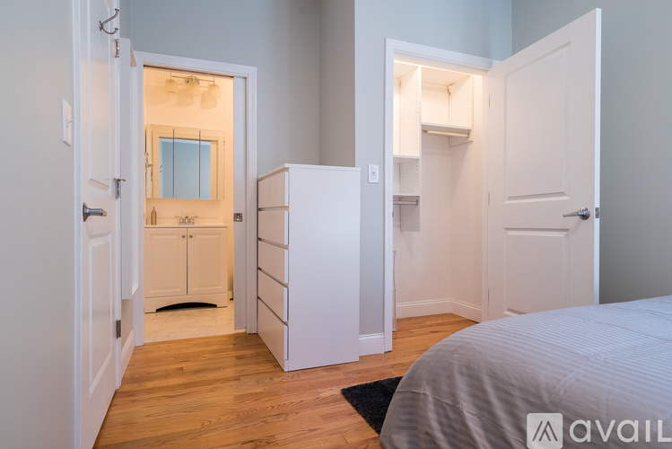 A bedroom with a bed, dresser, and wardrobe.