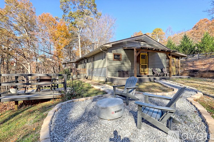 A rustic cabin with a gravel patio and a picnic table.
