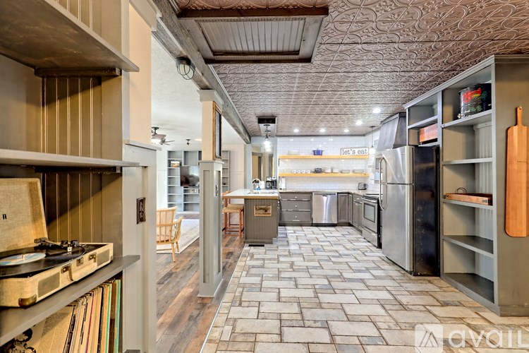A kitchen with a tile floor and a wooden ceiling.