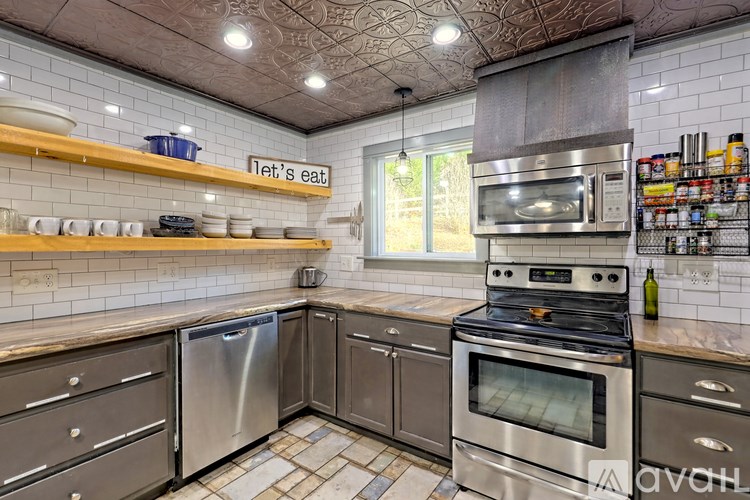 A kitchen with a stove top oven and a sign that says "Let's eat".