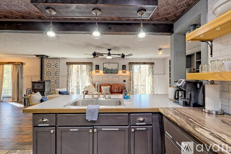A kitchen with a wooden ceiling and a large island with a sink.