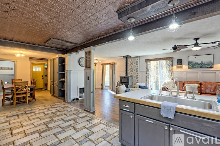 A kitchen with a stone floor and a wooden table.