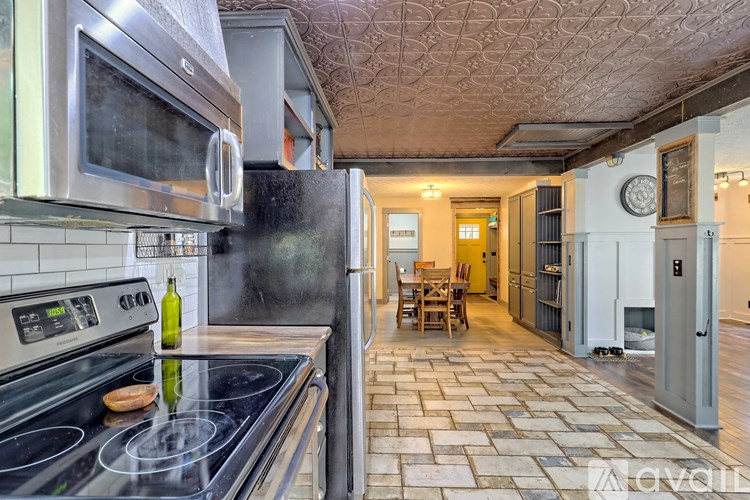 A kitchen with a black stove top and a tile floor.