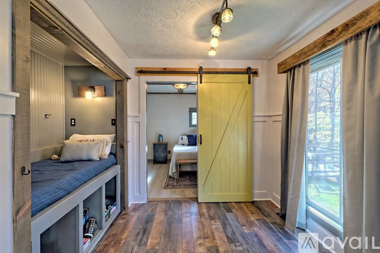 A bedroom with a bed on the left and a couch in the middle.