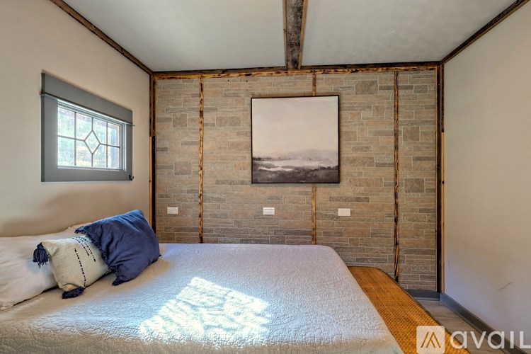 A bedroom with a large bed and a picture on the wall.