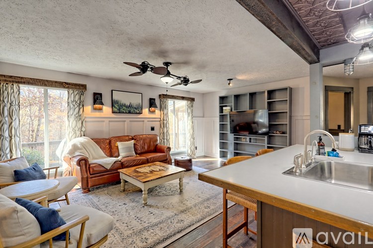 A living room with a brown leather couch and a wooden coffee table.