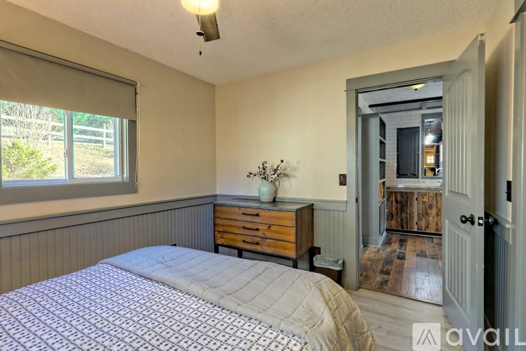 A bedroom with a bed, dresser, and window.