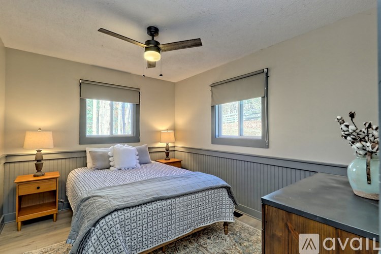 A bedroom with a bed, nightstand, and window.