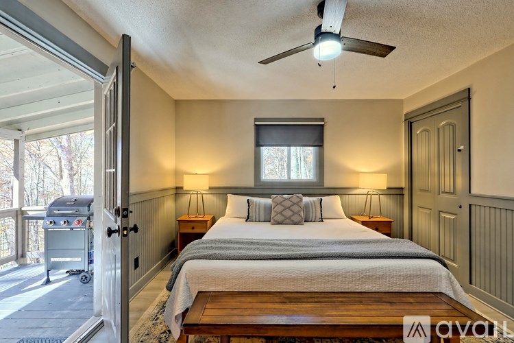 A bedroom with a bed, nightstands, and a ceiling fan.
