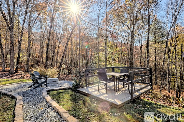 A sunny day in a backyard with a wooden deck and a gravel path.