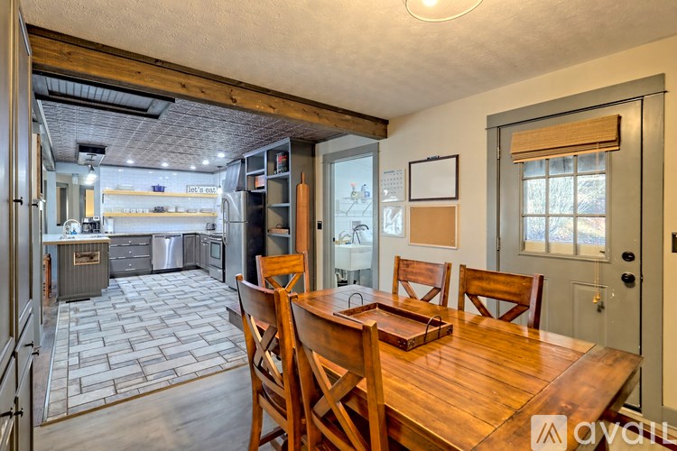 A kitchen with a dining table and chairs is shown.