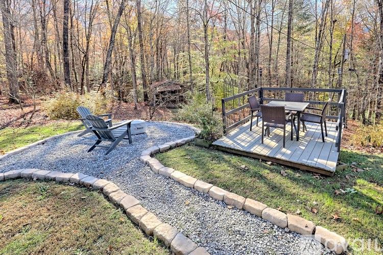 A backyard with a table and chairs on a deck.