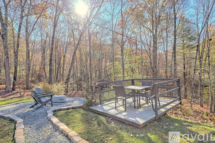 A sunny day in a backyard with a wooden deck and a gravel path.
