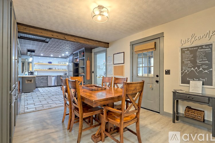 A dining room with a wooden table and chairs.