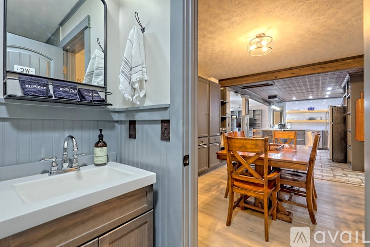 A kitchen with a white sink and wooden chairs.
