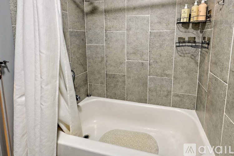 A white bathtub with a shower curtain and a towel hanging on the side.