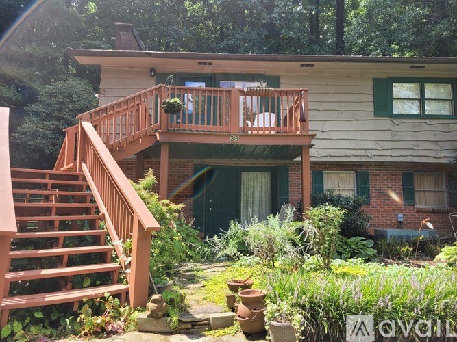 A house with a deck and stairs leading to the front door.