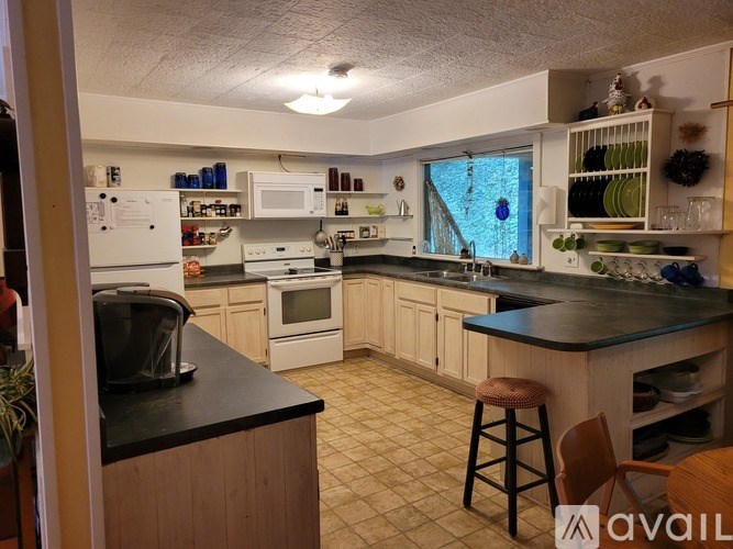 A kitchen with a black counter top and wooden cabinets.