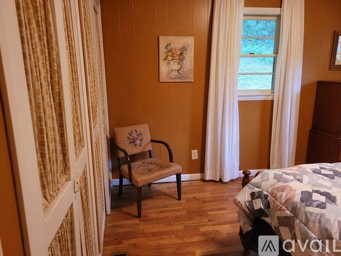 A room with a chair and a bed.