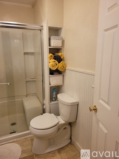 A white toilet is in a bathroom with a white door.