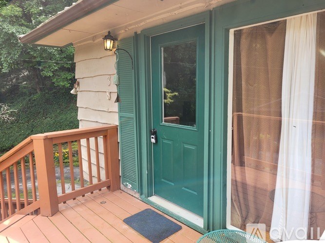 A green door is on a white house.