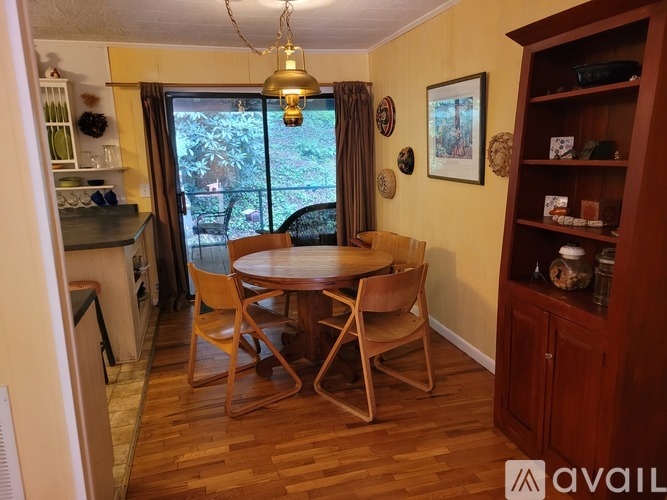 A dining room with a wooden table and chairs.