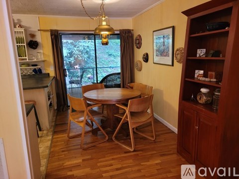 A dining room with a wooden table and chairs.